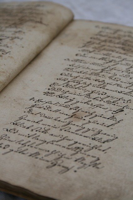 Livre antique en papier avec écriture manuscrite sur le christianisme, montrant comment exploiter les registres paroissiaux en généalogie